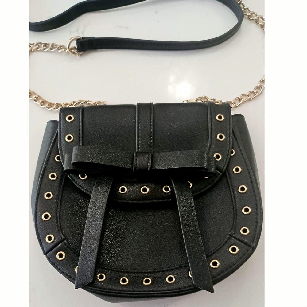 The Express Black Crossbody embellished with Bow metal grommets flap  closure.